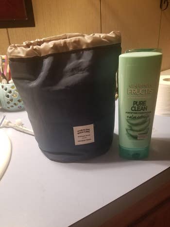 the bag sitting next to a full-size bottle of shampoo showing they're a similar height
