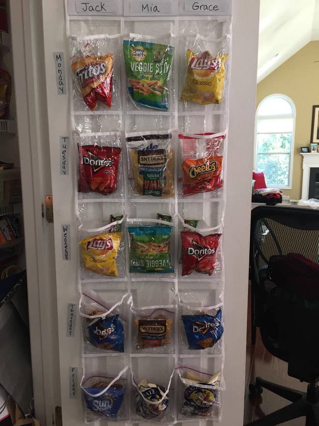 Hanging organizer with snacks in labeled pockets for three people: Jack, Mia, and Grace. Each row holds different snack brands