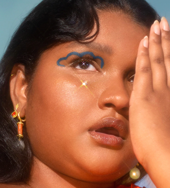 a model with a blue, cloud-like design drawn on their eyelid using the blue eyeliner
