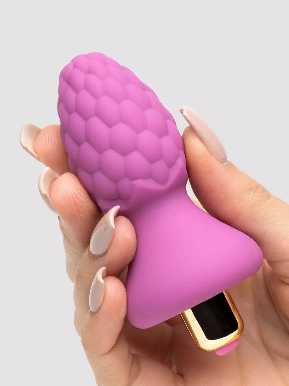 Model holding pink textured butt plug