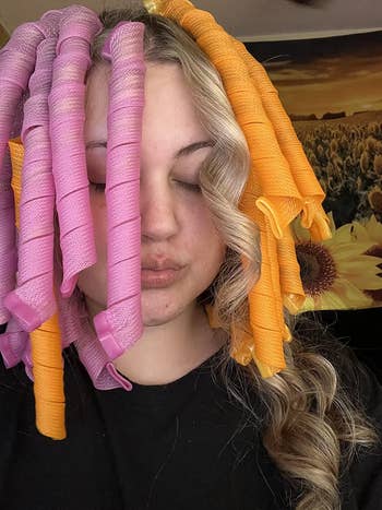 reviewer with colorful hairsbreadth curlers successful her hair, eyes closed
