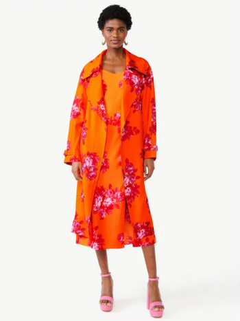 model in long orange and pink floral trench coat over matching dress
