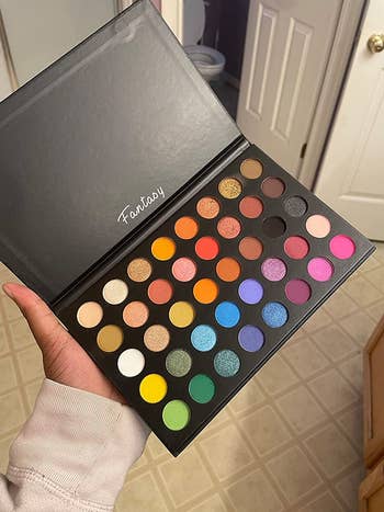 a reviewer holding the palette of 40 rainbow shades