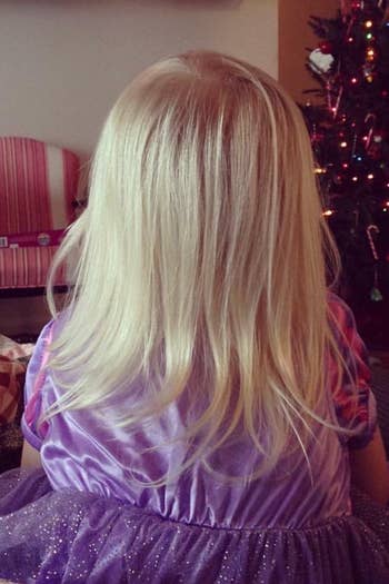 another reviewer showing back of their child's head with blonde hair smooth and free of tangles after using spray