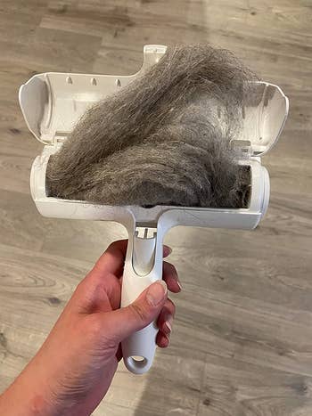 Reviewer holding open ChomChom with a ton of hair inside