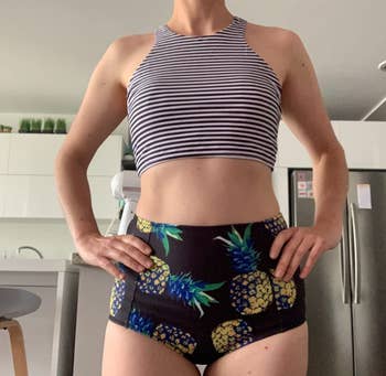 reviewer wearing swimsuit with striped top and pineapple bottoms
