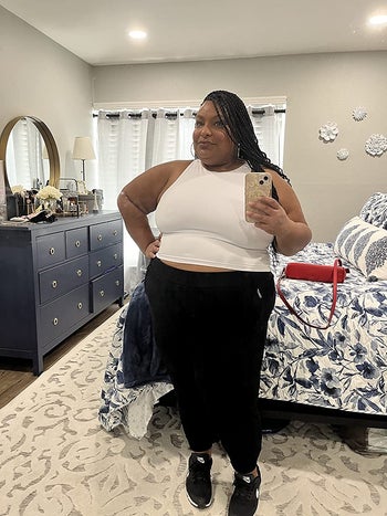 plus-size reviewer wearing the white version with black skinny pants