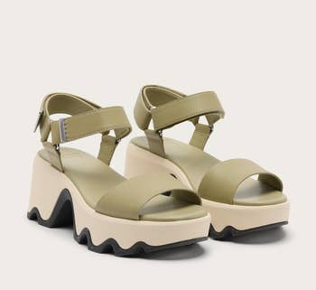 Platform sandals with thick, wavy soles and wide straps. Adjustable ankle strap with a buckle. Fashion-forward, modern plan suitable for casual wear