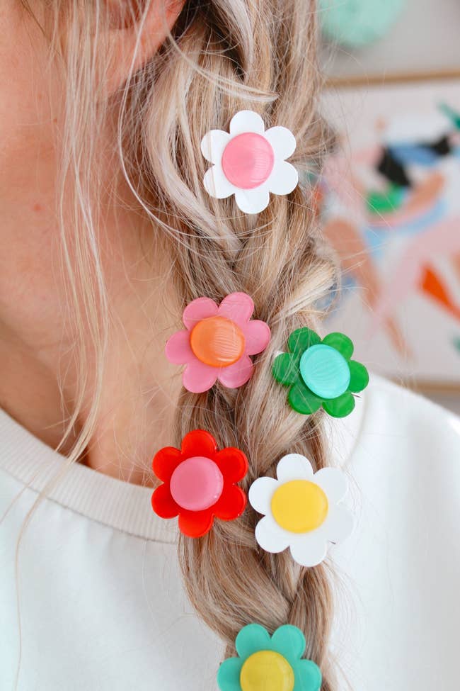 model wearing the different colored daisy flowers in a braid