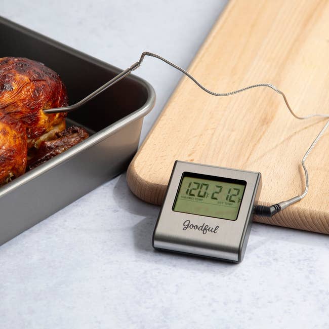 wired probe meat thermometer in a chicken with display screen giving temp reading