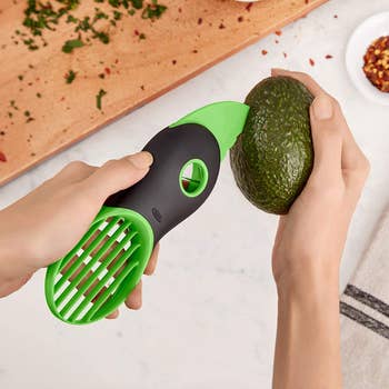 Model using avocado tool to slice open avocado