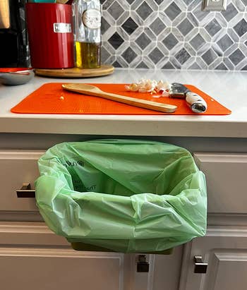 a reviewer photo of the bin lined with a compostable bag attached to a drawer 