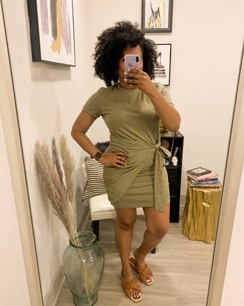 reviewer photo of them wearing the knotted t-shirt dress in light olive green