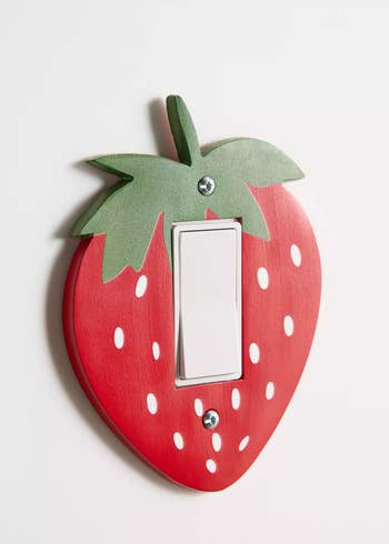 Strawberry-shaped light switch cover with green leaf detail, suitable for home decor