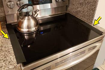 reviewer photo of black gap covers placed on each side of the stove