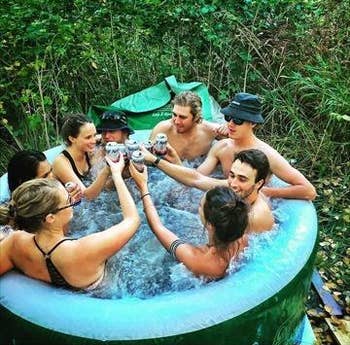 reviewers holding drinks in the hot tub
