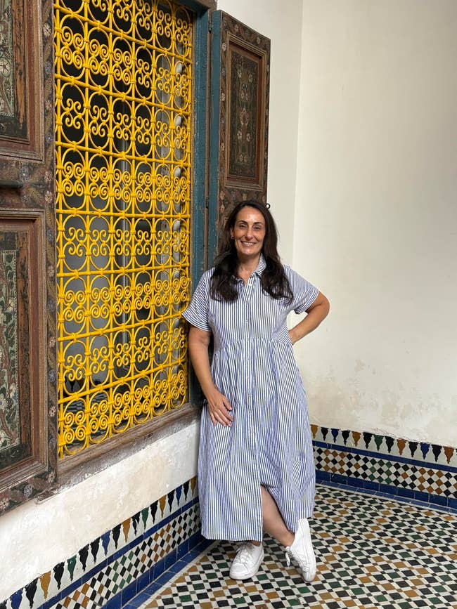 Person successful a striped formal and sneakers stands by ornate model successful a tiled room