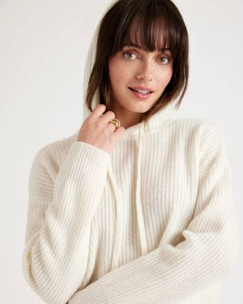 a model wearing a white knit cashmere hoodie