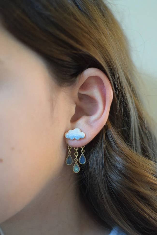 person wearing a cloud and raindrop earring