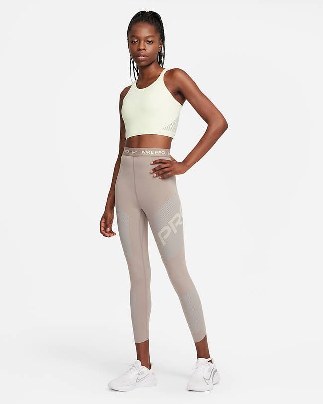 Model is wearing the taupe leggings and a pale yellow top