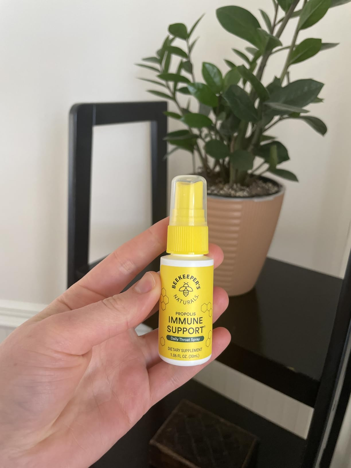 reviewer holding the tiny  spray vessel  with plants disposable   successful  the background