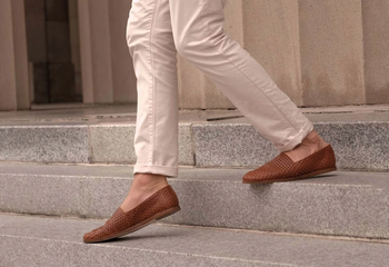 person wearing brown woven loafers