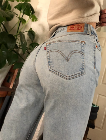 Reviewer showing back pocket of light wash version of jeans 