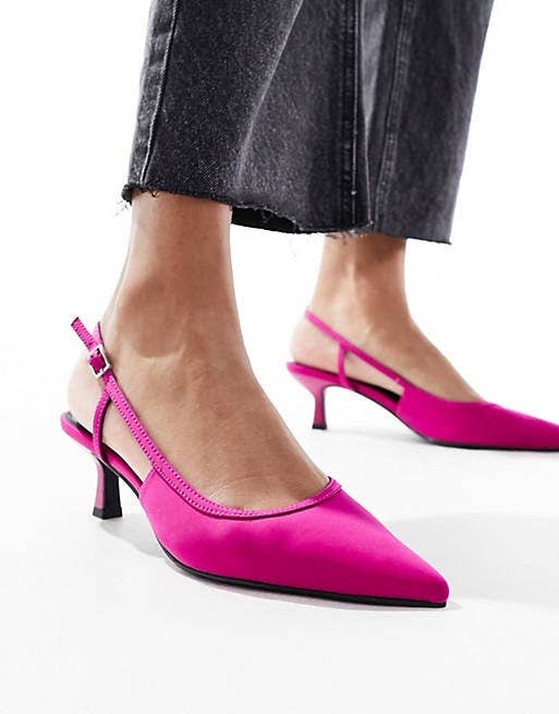 Person wearing black denim jeans with pink pointed-toe slingback heels