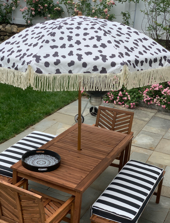 spotted umbrella attached to backyard table setting 