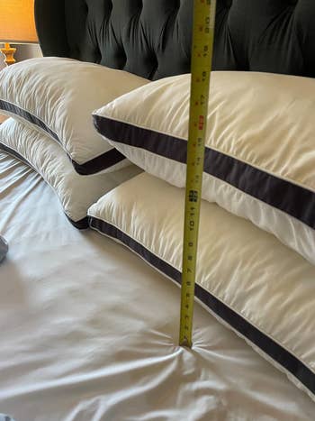 Measuring tape showing the height of luxury pillows on a bed