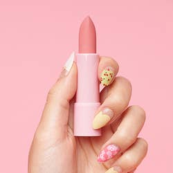 hand showing the light pink color of the lipstick