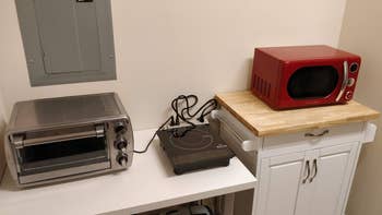 The burner on a reviewer's table next to a toaster oven and a microwave
