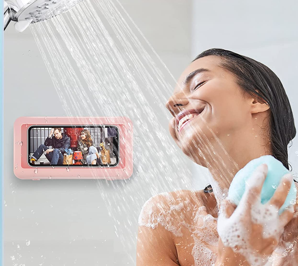 model showering while watching something on their phone, which is in the pink phone mount
