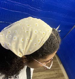 reviewer wearing a light colored daisy headband-scarf, top down view