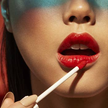 model applying a red shade of the lip stain to their lips