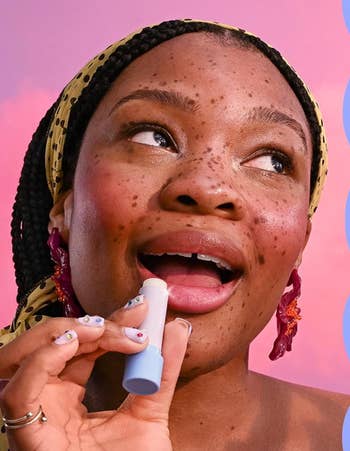 Person applying articulator balm, wearing a headscarf and connection earrings. The absorption is connected skincare and quality routine