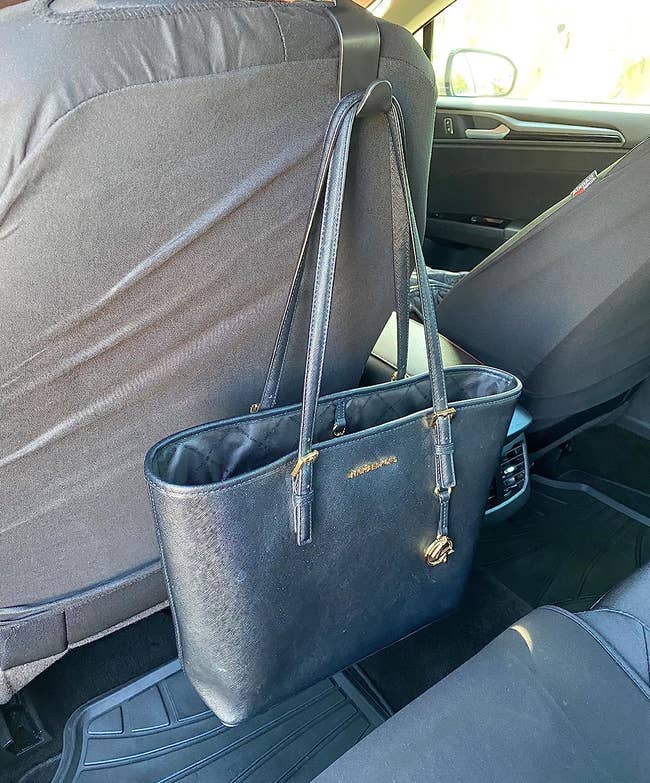 Reviewer's purse hanging from bag hook behind driver's seat