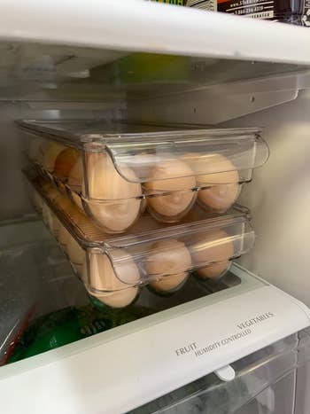 reviewer image of two egg holders filled with eggs stacked on top of one another inside of a fridge