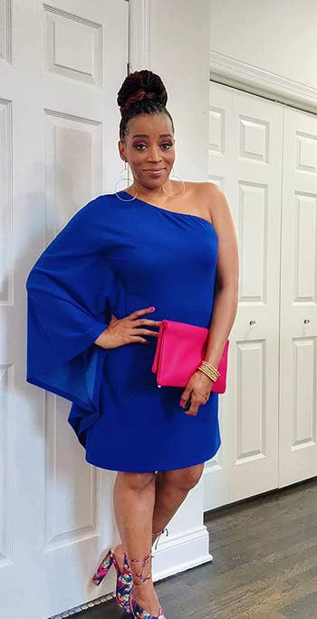 reviewer in the blue one-sleeve shift dress