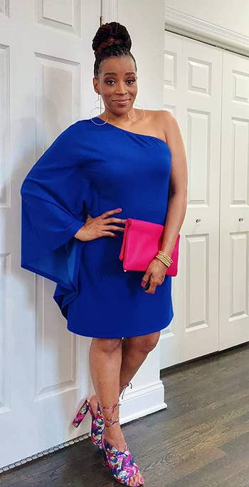 reviewer in the blue one-sleeve shift dress