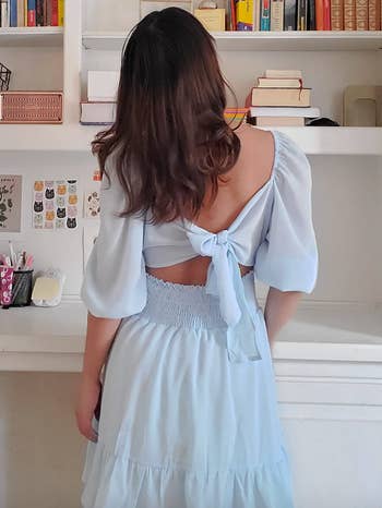 reviewer showing the open back of dress
