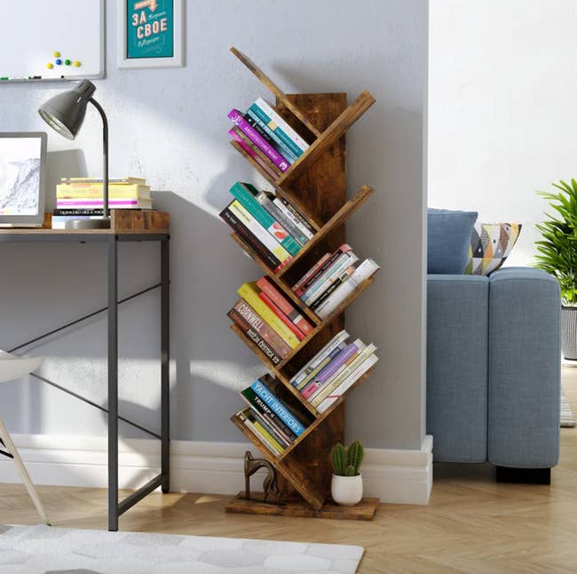 the rustic brown tree bookshelf with books on six of its tiers