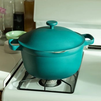 the teal pot on top of a stove