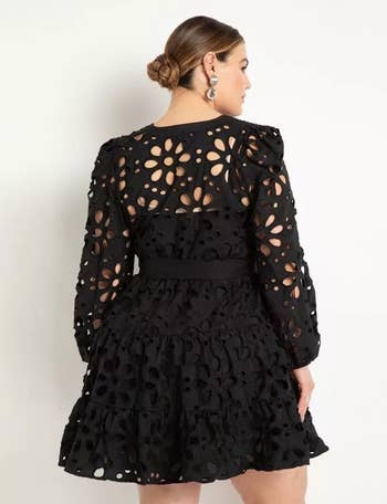 model seen from the back showing the eyelet design of the black dress