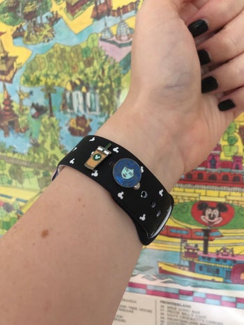 editor's wrist wearing an apple watch with a charm of ice coffee and madame leota