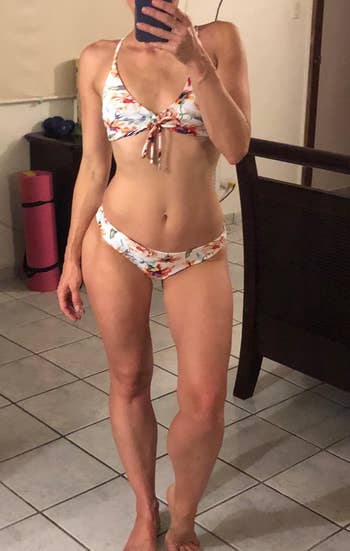 a reviewer wearing the floral side of the two piece swim set
