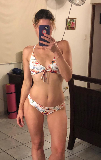 a reviewer wearing the floral side of the two piece swim set