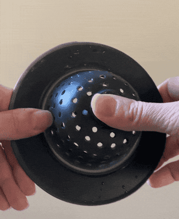 gif of BuzzFeeder pushing the sink strainer inside and out