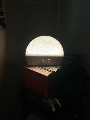 clock softly glowing and showing clip against a acheronian background