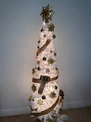 a reviewer's white tree with gold glittery ornaments